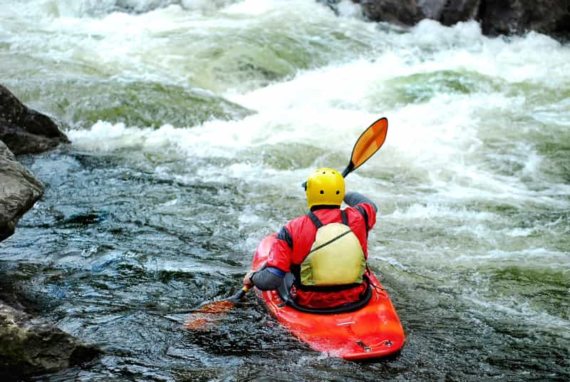 A Whitewater Kayak Surfing a Wave