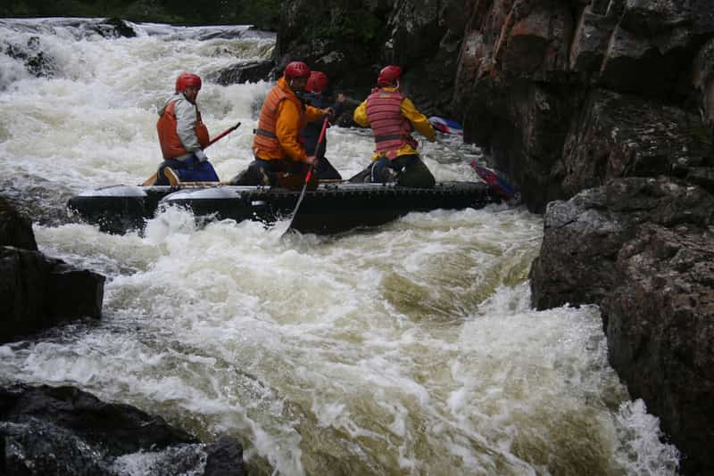 Adventure enthusiasts going through a rapid in the Kundalika river 