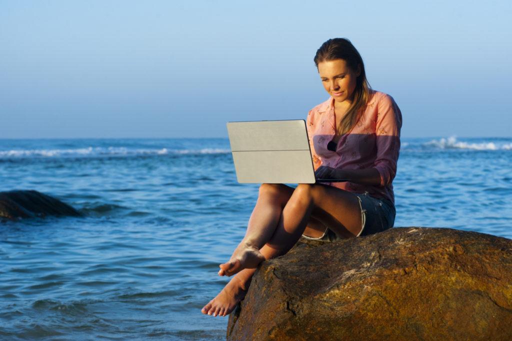 Woman working from a beach destination
