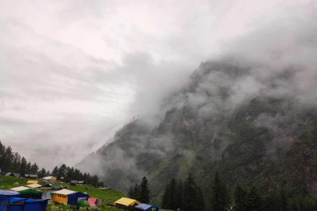 The misty weather at Kheerganga during best places to visit in July in India.