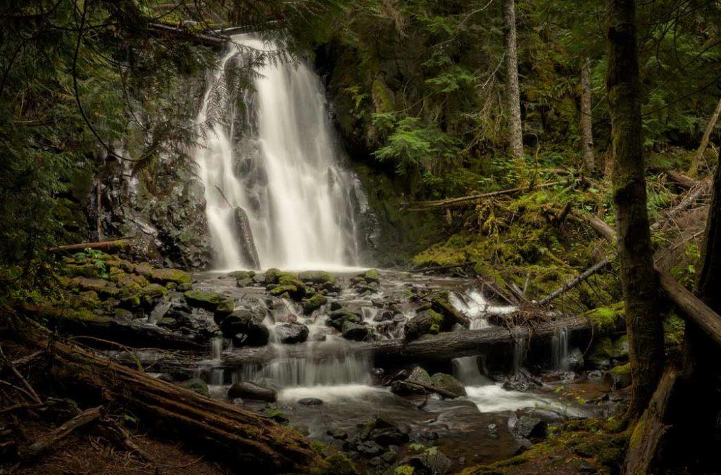 This mystical waterfall lies between mossy hills and offers an enchanting view from afar. 