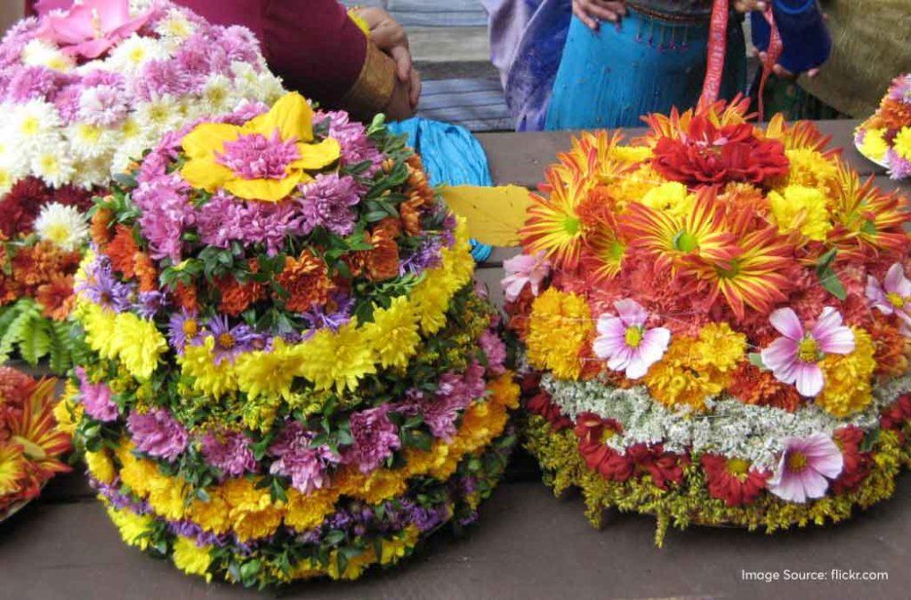 Women will take a copper plate which is also called the ‘Tambalan’. On this, they will place the flowers in concentric circles, one layer on top of the other, till we have a stack of flowers. 